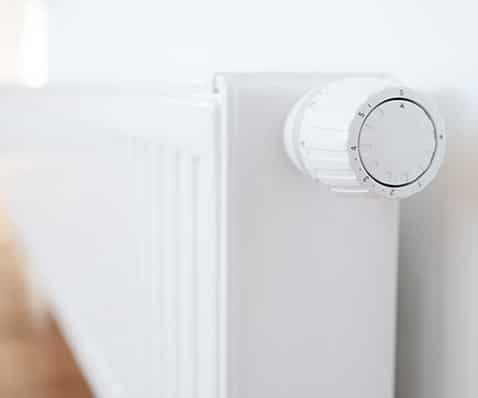 Vanne thermostatique de radiateur : Guide de réglage Radiateur à eau chaude blanc avec vanne thermostatique graduée pour régler précisément la température ambiante.